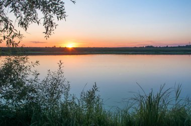 Rusya 'nın Bashkortostan cumhuriyetinde, Agidel' de küçük bir nehirde güzel bir gün batımının tadını çıkarıyorum.