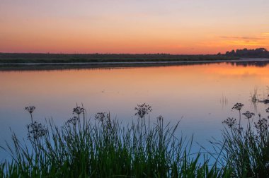 Rusya 'nın Bashkortostan cumhuriyetinde, Agidel' de küçük bir nehirde güzel bir gün batımının tadını çıkarıyorum.