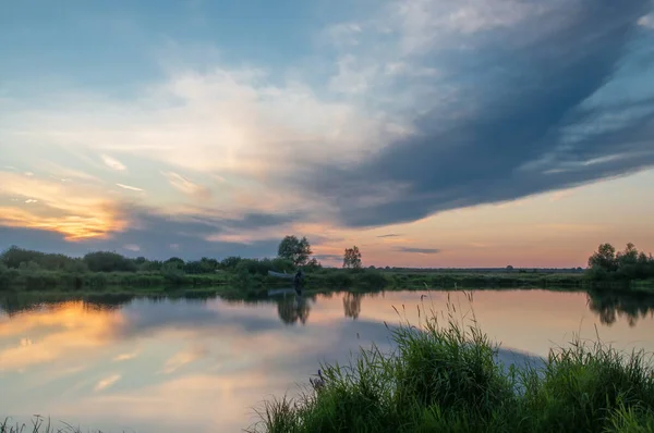 Rusya 'nın Bashkortostan cumhuriyetinin Agidel kasabasındaki küçük nehrin yakınındaki bir ormanda günbatımının tadını çıkarıyorum.
