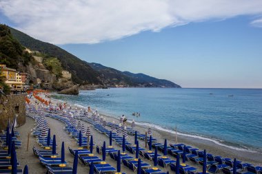 Monterosso al Mare, İtalya - 8 Temmuz 2017: Renkli Şemsiyeli ve Güneş Yataklı Fegina Sahili Turistleri