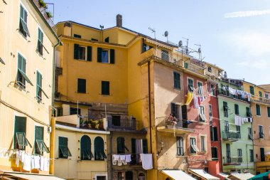 Vernazza, İtalya - 8 Temmuz 2017: Güneşli bir günde geleneksel renkli bir binanın balkonunda oturan bir çiftin görüntüsü