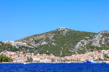 Hvar, Hırvatistan - 2 Ekim 2011: Güneşli bir günde Hvar yakınlarındaki Geleneksel Eski Ev ve Teknelerin Görünümü