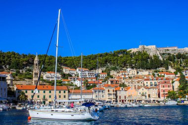 Hvar, Hırvatistan - 2 Ekim 2011: St Mark 's Kilisesi ve İspanyol Kalesi Arkaplanda bulunan Tekneler ve Geleneksel Eski Evlere Bakış