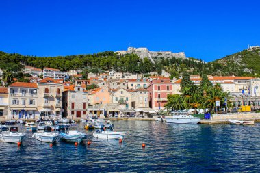 Hvar, Hırvatistan - 2 Ekim 2011: Arka planda İspanyol Kalesi olan Tekneler ve Geleneksel Eski Evlere Bakış