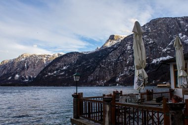 Hallstatt, Avusturya - 4 Mart 2017: Bakcground 'da dağları olan Hallstatt Gölü' ndeki bir restoranın görüntüsü