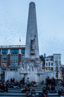 Amsterdam, Hollanda - 11 Mart 2017: Kent Merkezi 'ndeki Baraj Meydanı' ndaki Ulusal Anıtın Önünde Oturan İnsanlar