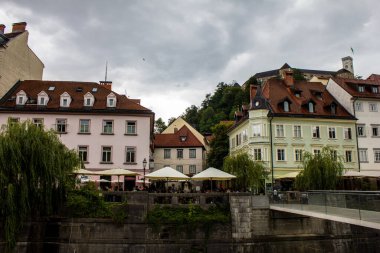 Ljubljana, Slovenya - 15 Temmuz 2017: Ljubljana şehir merkezindeki Ljubljanica Nehri kıyısındaki bir kafede oturan insanların görüntüsü