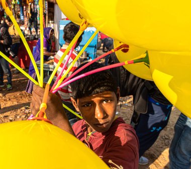 Zavallı küçük bir çocuk balonları uyuşturucu festivalinde satıyor.