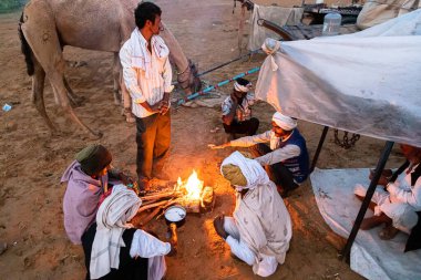 Hint kamasörleri sabahın erken saatlerinde çölün kum tepelerinde çay yapıyorlar. Konuya özen gösteriyorlar ve gürültü ve tahıl ekliyorlar..
