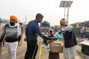 Delhi sınırında protesto sırasında yemek servisi yapan yaşlı bir çiftçi..