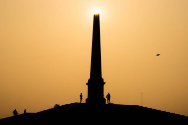 Delhi 'de gün doğumuyla birlikte taç giyme parkında güzel bir siluet manzarası..