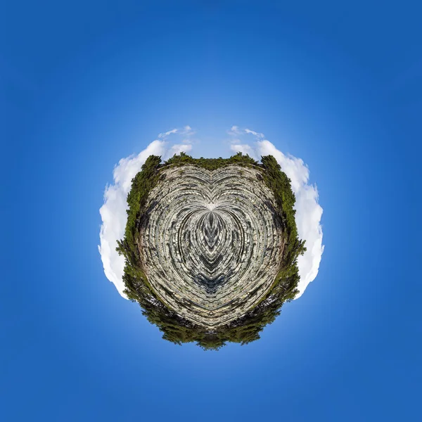 Polar coordinates, a circular image of a blue sky, picturesque rocks on a stone wild beach. Forest and camping area on the outskirts of the resort town. Russia, Black Sea coast