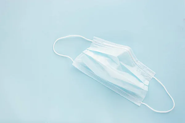 Maschera medicinale usato con cinghie auricolari in gomma su sfondo blu. Proteggere da virus e batteri. Concetto banner — Foto Stock