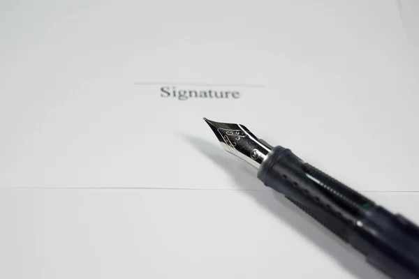 A pen and a signature on a contract