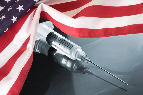 Flag of America, syringe and vaccination against corona virus