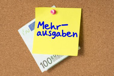 Bir pin tahtası, bir avro banknot ve aşırı harcama üzerine bir not.