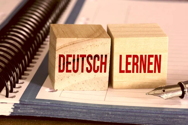 Two wooden cubes and words Learn German
