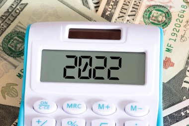 Dolar banknotları, hesap makinesi ve 2022 yılı.