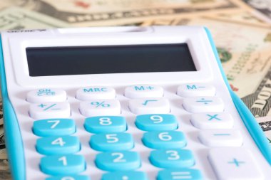 Bir hesap makinesi ve dolar banknotları