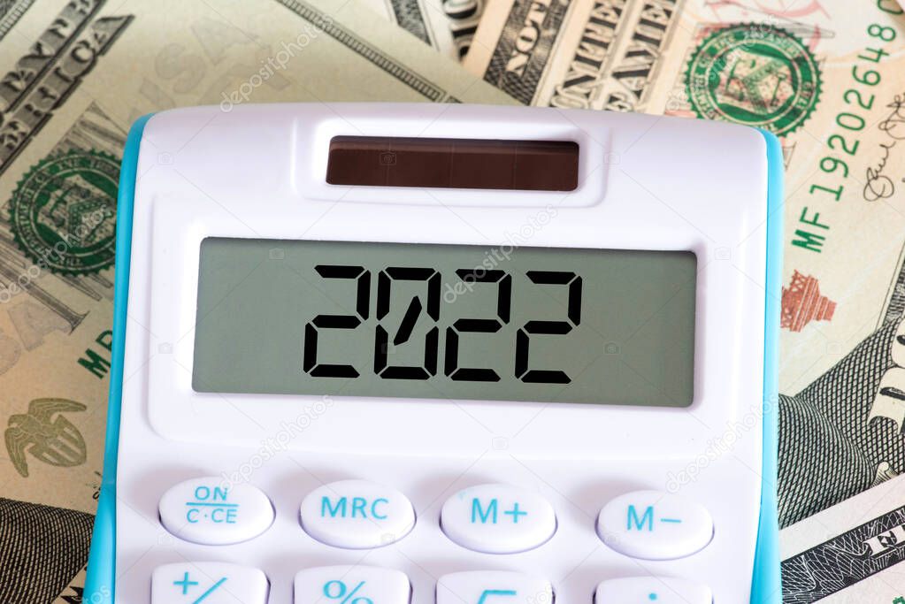 Dollar banknotes, calculator and the year 2022