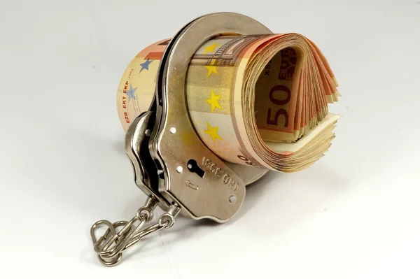 Money and handcuffs — Stok fotoğraf