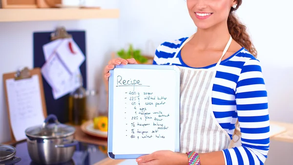 Woman in the kitchen at home, standing near desk with folder — Stock Photo, Image