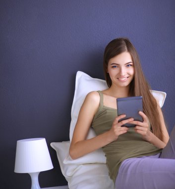 bir yastık ve uçak tablo ile katta oturan güzel esmer kadın