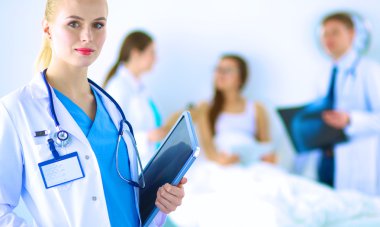 Kadın doktor hastanede dosyayla bekliyor.