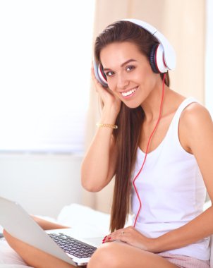 Genç güzel kadın yatakta müzik