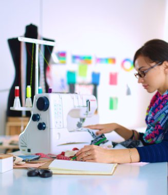 Çalışırken dikiş diken genç bir kadın.