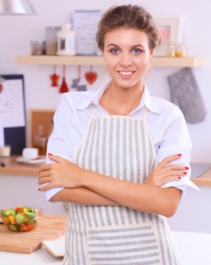 Noel arka plan üzerinde duran mutfakta gülümseyen genç kadın