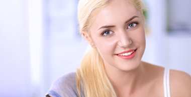 Genç ve güzel bir kadın odasında kanepede oturuyor.