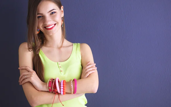 Mujer joven de pie cerca de la pared oscura — Foto de Stock