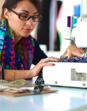 Çalışırken dikiş diken genç bir kadın.