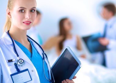 Kadın doktor hastanede dosyayla bekliyor.