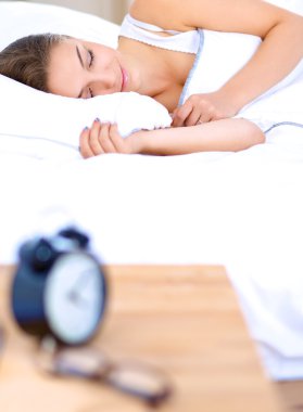 Yatakta rahat ve mutlu bir şekilde yatan güzel bir genç kadın.