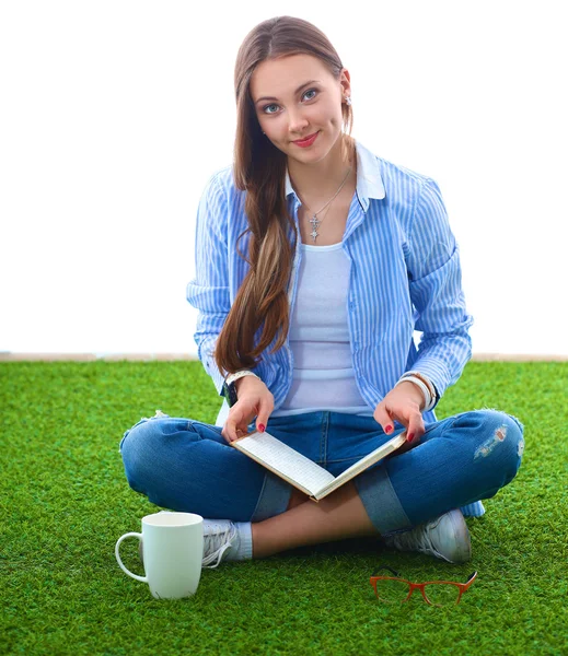 Jonge vrouw zitten met boek op gras — Stockfoto