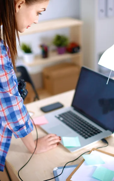 Female photographer sitting on the desk with laptop — Stock Photo, Image