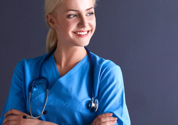 Jeune médecin femme avec stéthoscope isolé sur fond gris — Photo