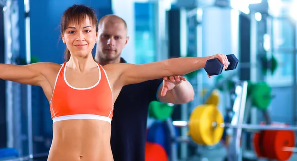 Vacker kvinna på gymmet tränar med hennes tränare — Stockfoto