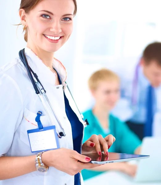 Médica atraente na frente do grupo médico Imagem De Stock