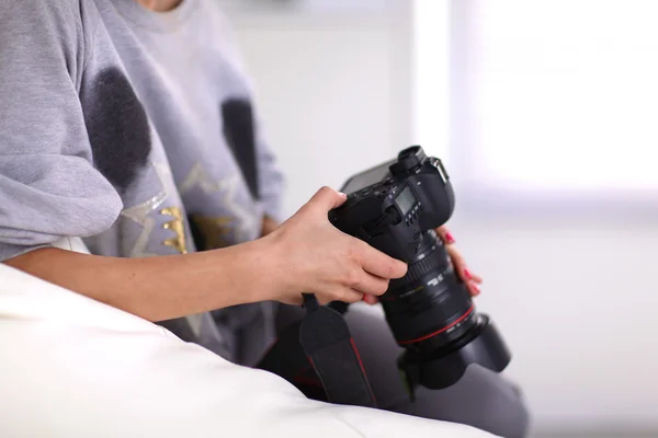 Vrouw zitten op een sofa in haar huis met camera — Stockfoto