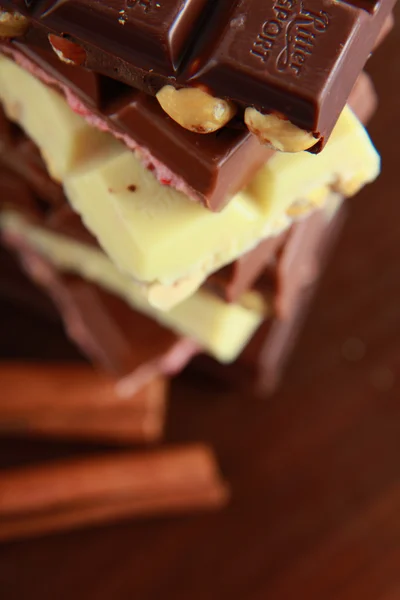 Stapel von Schokoladenstücken auf einem Holzhintergrund — Stockfoto
