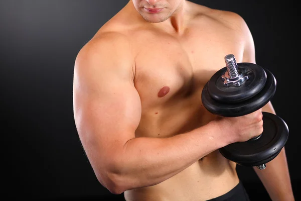 Bonito homem musculoso trabalhando com halteres — Fotografia de Stock