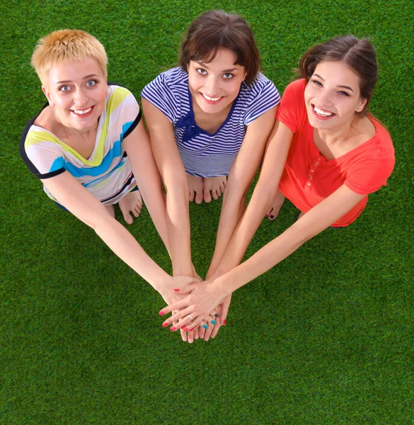 People joining their hands standing on green grass — Stock Photo, Image