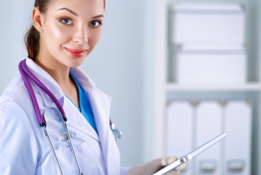 Kadın doktor hastanede dosyayla bekliyor.