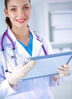 Kadın doktor hastanede dosyayla bekliyor.