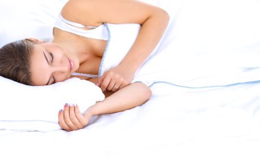 Yatakta rahat ve mutlu bir şekilde yatan güzel bir genç kadın.