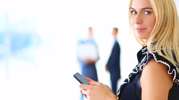 Hermosa mujer de negocios usando el teléfono celular, de pie en la oficina —  Fotos de Stock