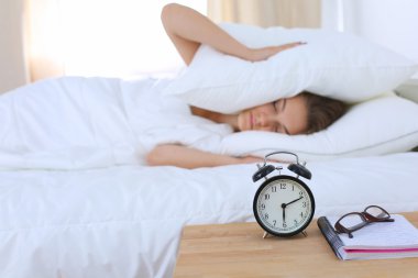 Genç bir kadın sabah alarmını erteliyor.